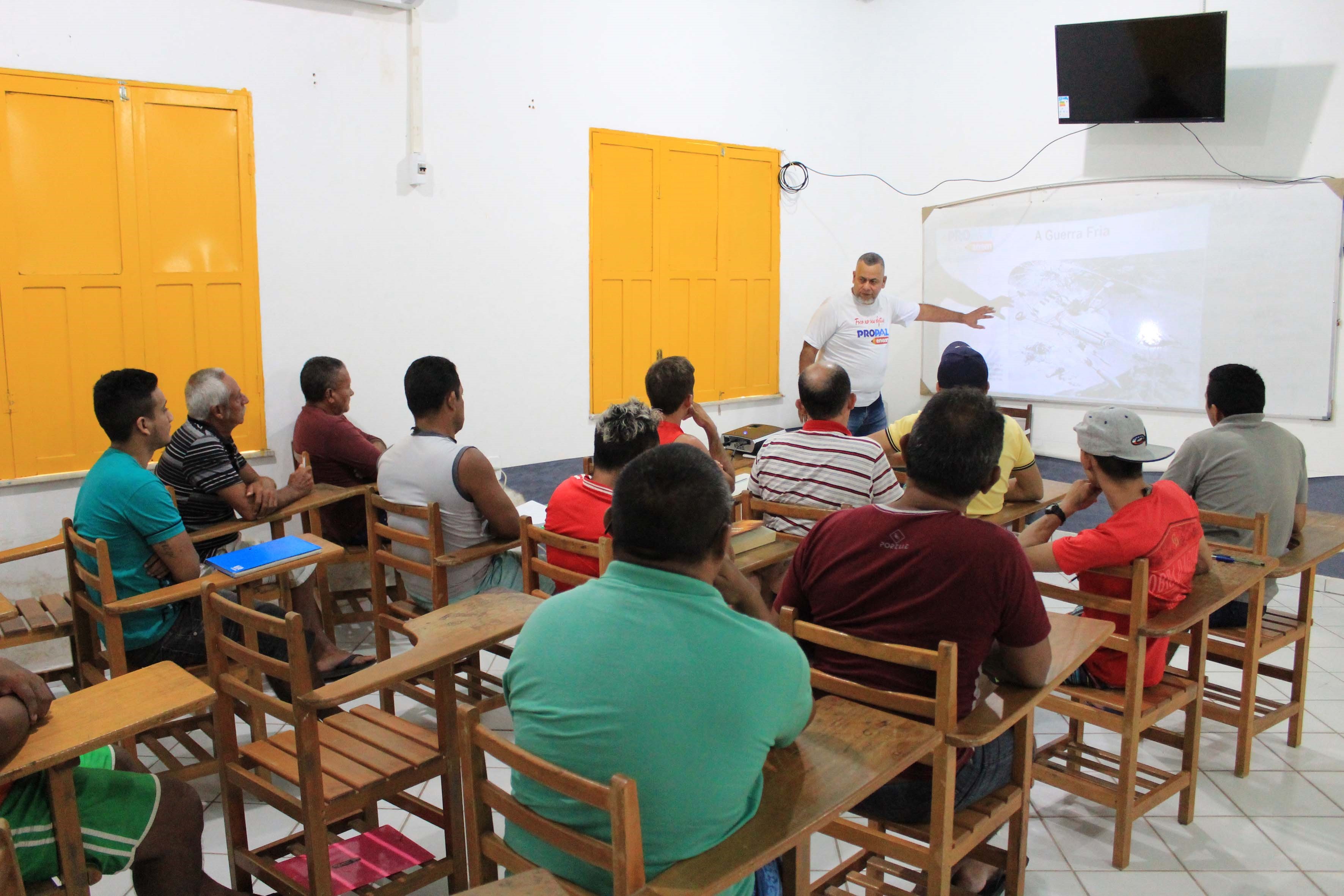 alunos em sala de aula, sendo ensinados pelo professor